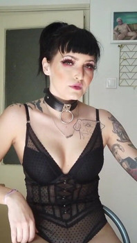Señora gótica tatuada fumando en la cocina