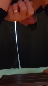 Sissy in een zwarte jurk en netkousen berijdt een dildo