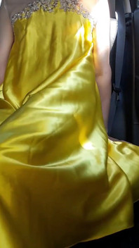 Il travestito sexy si masturba indossando un abito lucido di raso giallo
