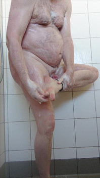 샤워 중에 젖은 채 서 있는 나체인 소년
