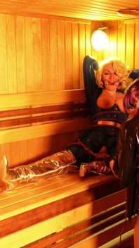 Processo di bondage nella sauna: sexy miLF sottomessa imbavagliata in lattice e la sua dominatrice di gomma