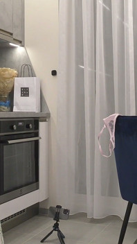 Dona de casa sexy e gostosa de peitões naturais em uma blusa do Cardigã mostra sua buceta e bunda nua faz um striptease