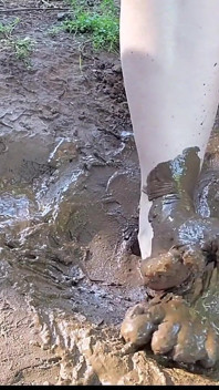 裸足で押しつぶされ、泥の中で遊ぶ、汚れた足