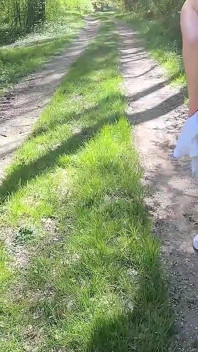 Une belle femme se déshabille et marche nue avec une pompe à clito à l’extérieur dans une forêt publique