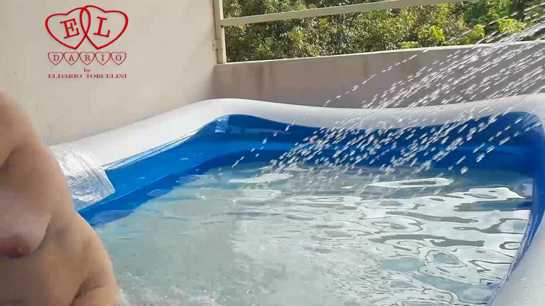 Strange stepfamily: Nude couple plays in the outdoor nudist swimming pool.