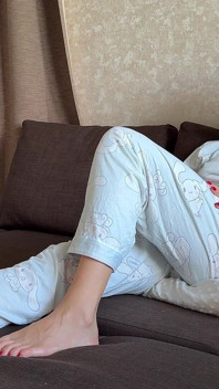 Pedos En Pijama En Una Almohada Mientras Está Sentado En El Sofá
