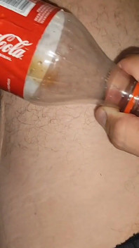 Il ragazzo si mette il cazzo incastrato in una bottiglia di coca-cola