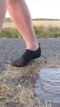Bright Pantyhose and Beach Shoes in Puddle