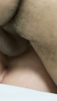Piercing no umbigo e brincos de aro - gata de cabelos escuros leva um grande pau preto em lençóis brancos