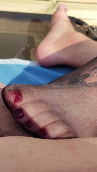 Footjob nilon hitam glossy im garten
