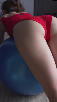 Kırmızı vücutlu fitness kızı egzersiz topunda zıplıyor