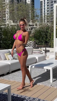 Monika Fox poseert in roze bikini en zwemt in het zwembad omringd door wolkenkrabbers