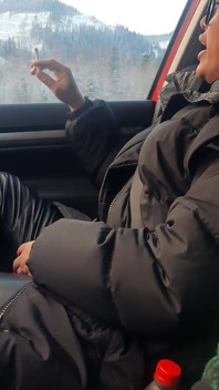 Grandes labios fumando en pantalones de cuero del coche