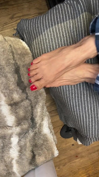 Pies pequeños y sexy con esmalte de uñas rojo en dedos largos