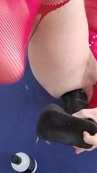 Transvesthemd in roten dessous reitet riesigen dildo und kommt