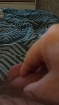 Meu amigo está deitado na cama brincando com o pau grande dele
