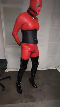 Červená latexová kombinéze, blondýnka v overknees, oblékání a příprava na sezení, roubík, spoutaný