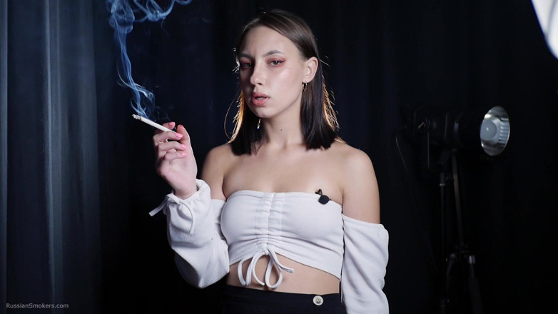 Russian Smokers: Brunetă elegantă care fumează țigară în scenă întunecată la studio