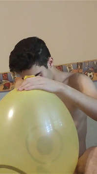 Mamando un enorme globo sonriente mientras se masturba