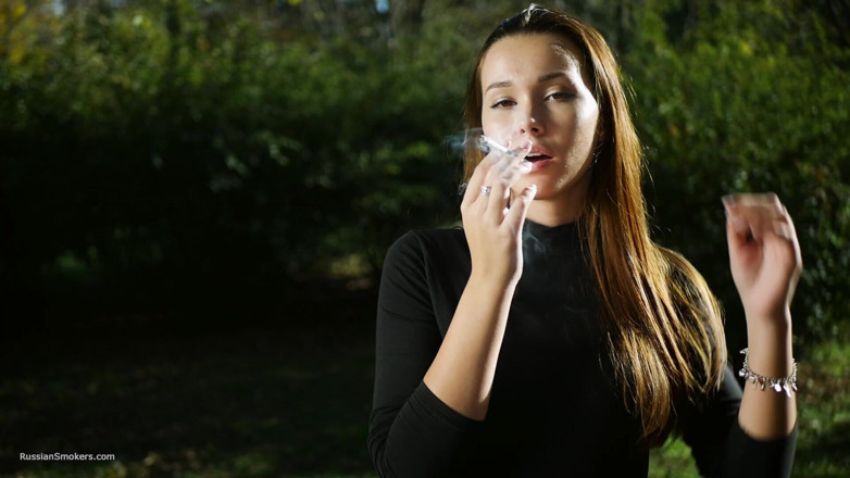 Russian Smokers: Une beauté russe séduisante fume une cigarette dans la nature