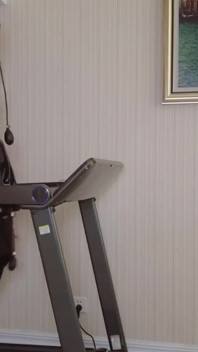 Mz24 - a Girl Bound to a Treadmill with Metal Restraints and Shackles