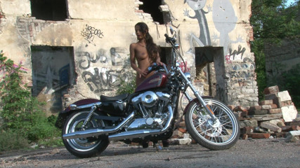 Public Entertainment: Outstanding brunette teasing outdoors by the chopper