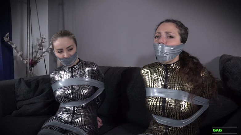 Gag Attack: Aubrey et Julia - combinaison en bondage sur bande