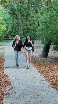 Două stăpâne lesbiene se plimbă prin parc