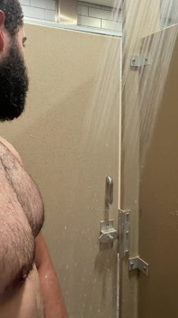 Fella barbudo muscular atrapado en duchas