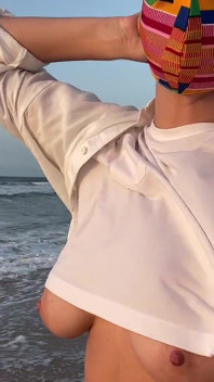 Blondă cu sâni mari fără sutien mergând pe stradă