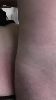 Une MILF attachée à une chaise suce, se doigte et se fait baiser devant une fenêtre ouverte