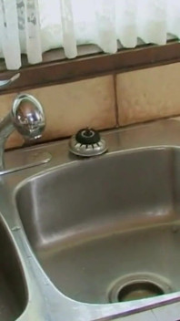 Tesão morena se masturba com torneira de cozinha