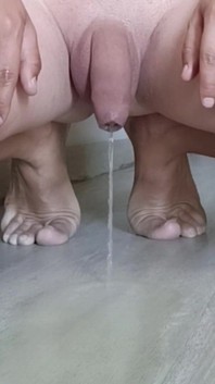 Đi tiểu trong khi quỳ trên mặt đất với đôi chân trần truồng