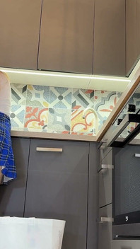 ジャグラーの女の子は、キッチンでミニスカートの下にパンティを見せるために、長い大学風の制服スカートを履いていて、