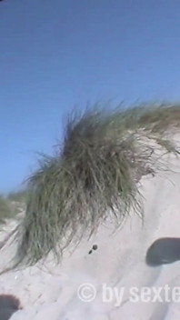 Ein haariges teen schießt ihren freund mit einer kamera am strand