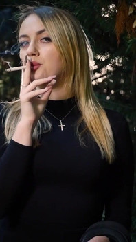 Gorąca blonde babe palenie jeden czarnych papierosów w naturze