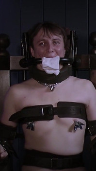 Ricky in einem Bondage-Stuhl, Stahlknebel und Sockenpolsterung.