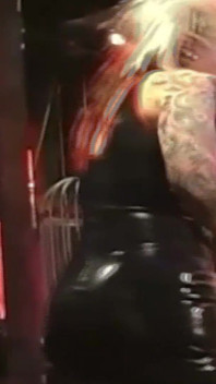 La padrona in lattice tatuata domina il suo schiavo maschio con il collare