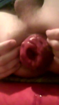Um jovem cara gostoso sentado em uma cadeira mostra seu prolapso anal