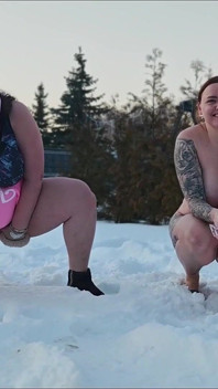 Swingers. Twee getrouwde stellen spelen naakt in de sneeuw in buiten. de vrouwen plassen in de sneeuw en de mannen likken het af