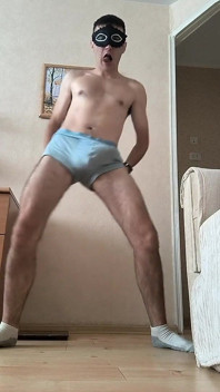 Young Boy with Mask Dances Striptease in Socks Under Music