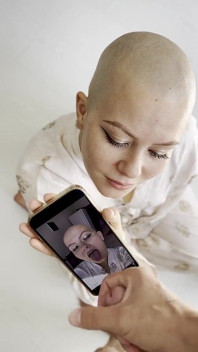 Cumtribute chica calva limpiando su teléfono después de