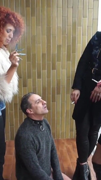 Fur-clad Femdoms Dominate Submissive on Balcony
