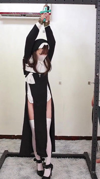 La novia interpreta a una monja, esposada y encadenada, atada a un marco de hierro