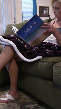Elle lit et repose ses pieds sexy