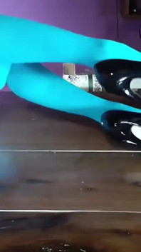 MiLF con belle gambe in collant e tacchi sdraiata sul tavolo