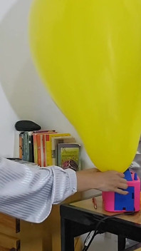 Marianna se snaží nafouknout svůj čtverhraný balon, aniž by ho praskla