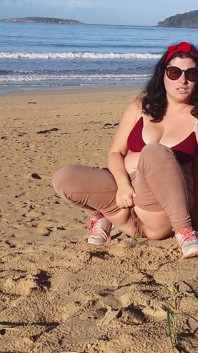 誰もいない公共のビーチで小便をする女性