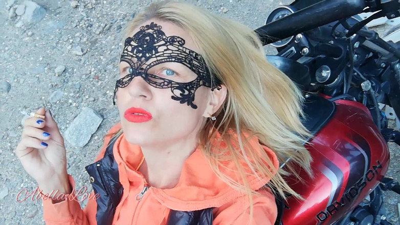 Abella Love: Red lips blonde smoking sensually on Rasta bike outdoor