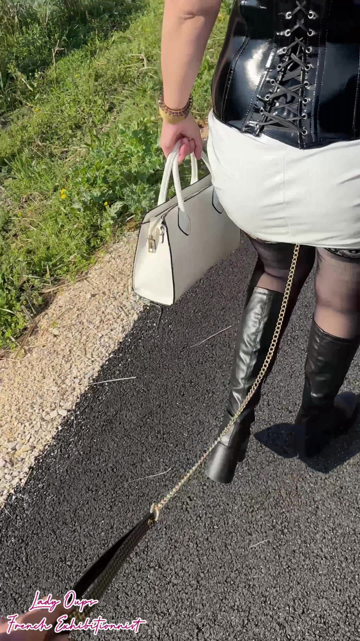 Lady Oups: ラテックスのミニドレスで首にリードをつけた屋外ウォーク